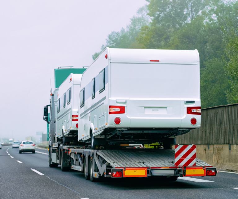 Should I choose enclosed or open air transport for my RV?