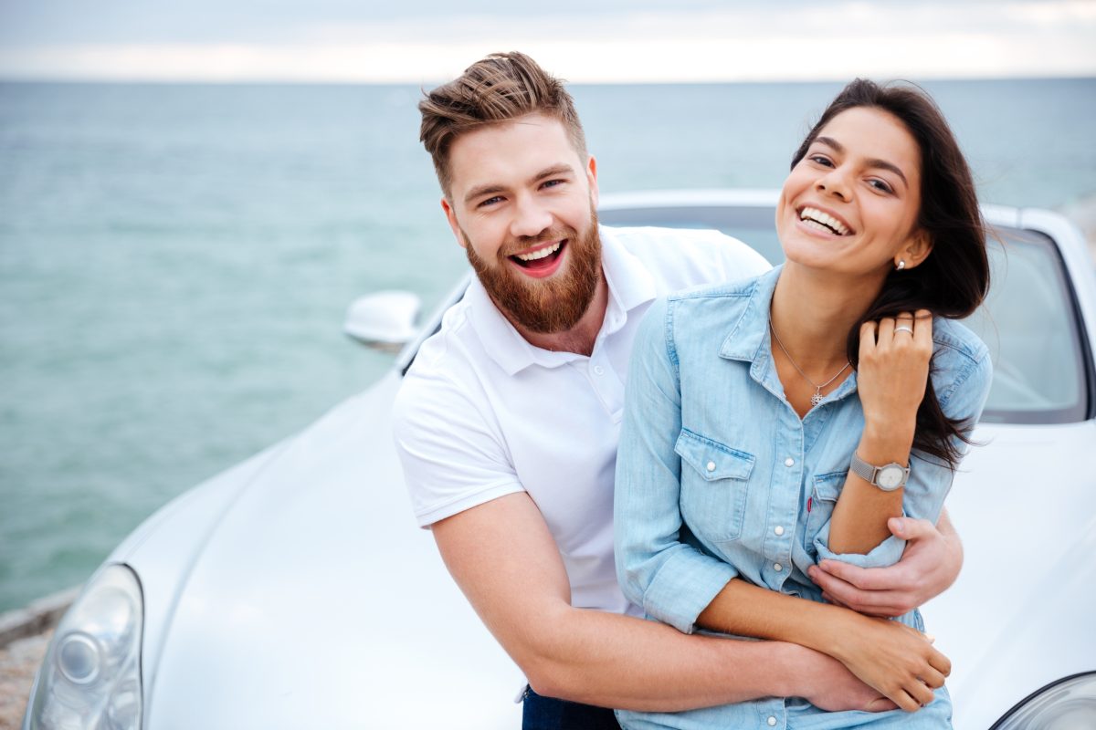 graphicstock happy smiling couple on a date standing near car at the seaside BOWOe8hrng